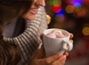 Person warming their hands on a cup of hot chocolate