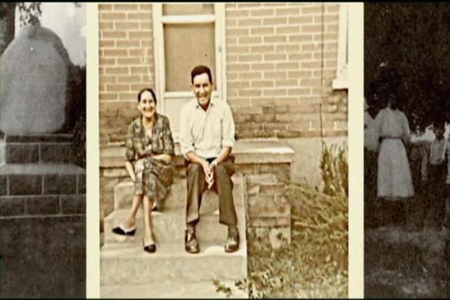 Photograph of smiling older couple sitting on porch stairs.